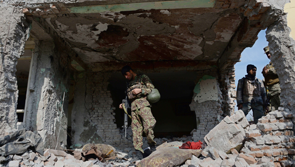Afghan security personnel inspect a building used by insurgents to launch an attack on the Pakistan consulate in Jalalabad, on Wednesday (AFP photo)